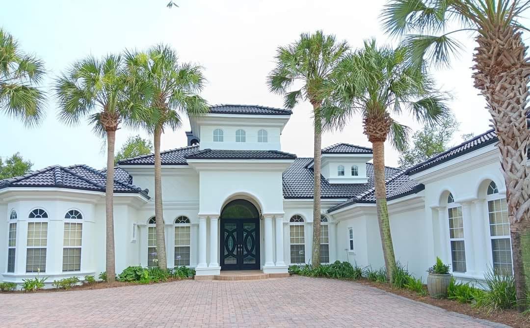Freshly painted white Mediterranean coastal home with palm trees on the Gulf Coast